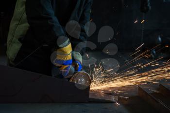 worker works with metal, sparks at factory