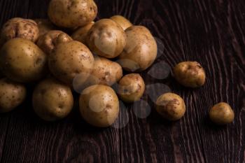 Freshly grown potato on wooden table