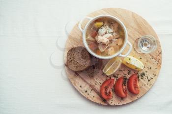 Russian traditional fish soup - ukha, served with bread lemon tomato and vodka