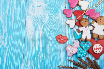 Gingerbreads for Valentines Day or wedding theme on blue wooden background