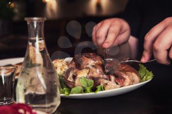 Man eats tasty dish of pork shank, closeup photo