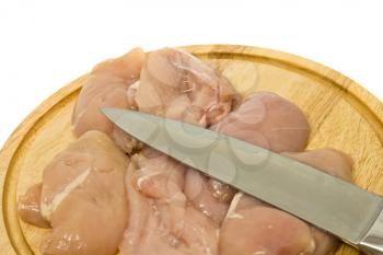 Close-up of Chicken fillet and knife on hardboard over white
