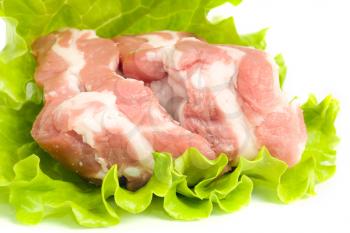 Pieces of Pork meat on green salad. Isolated over white