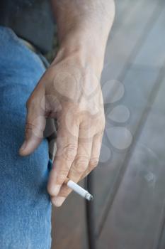 Royalty Free Photo of a Man's Hand Holding a Cigarette