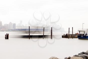 New York, USA-June 2, 2015: East River Ferry coming in for docking on a foggy day.