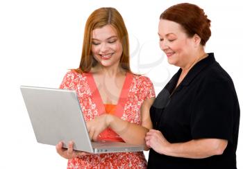 Two women using a laptop and smiling isolated over white