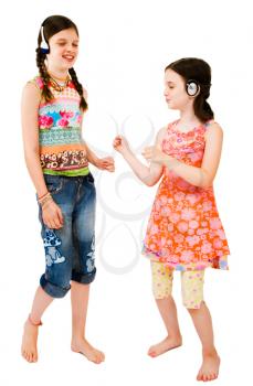 Two girls listening to music on headphones isolated over white