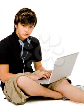 Fashion model using a laptop and posing isolated over white