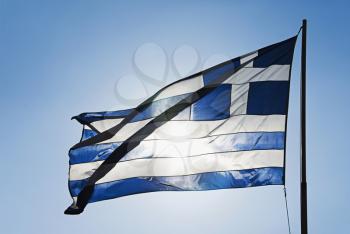 Greek flag fluttering against the blue sky, Athens, Greece