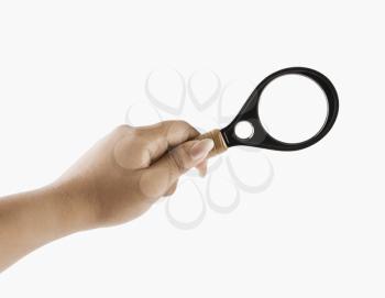 Close-up of a woman' hand holding a magnifying glass