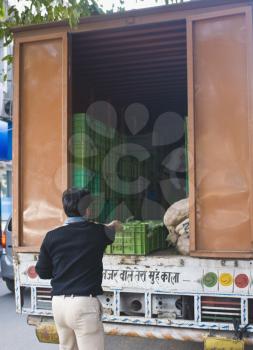 Two men unloading vegetables in a truck, New Delhi, India