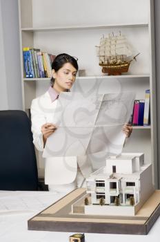 Businesswoman looking at a blueprint in an office