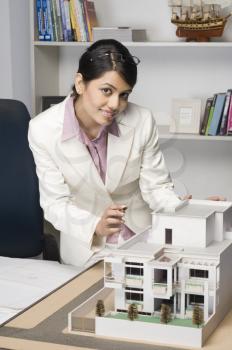 Portrait of a businesswoman near a model home in an office