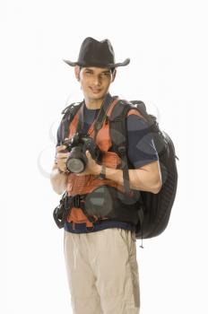 Portrait of a young male photographer holding a digital camera