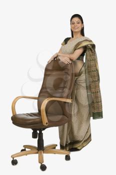 Businesswoman leaning against an office chair