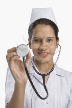 Female nurse holding a stethoscope and smiling