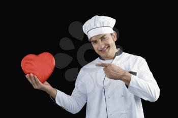 Chef pointing towards a heart shape gift