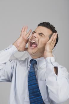 Businessman shouting with eye closed