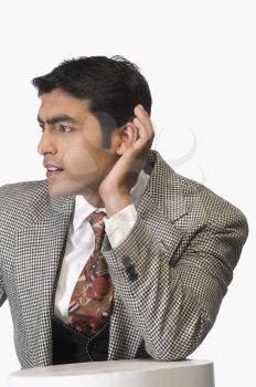 Businessman cupping his ears