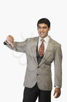 Businessman showing thumbs down and smiling