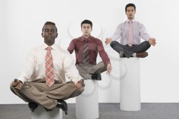 Three businessmen practicing yoga