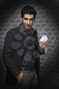 Portrait of a man holding three aces