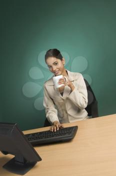 Businesswoman working in an office with a cup of coffee