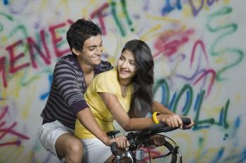 Couple riding a bicycle and smiling