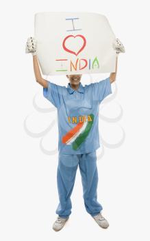 Woman in cricket uniform holding a placard with text I Love India written on it