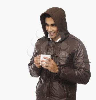 Man holding a cup of coffee and smiling