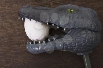 Toy crocodile holding an egg in jaw