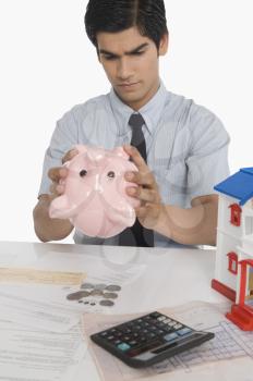 Real estate agent looking into a piggy bank
