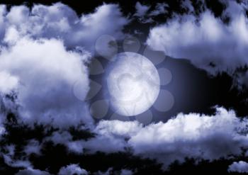 The moon in clouds in the night sky