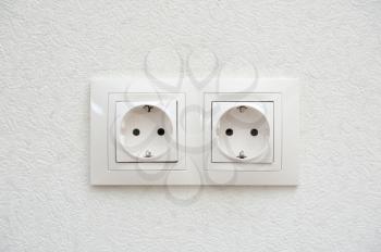 Two electrical sockets paired on the wall