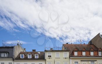 Beautiful exterior of the upper floors and roofs of residential buildings against the sky in Europe, Germany. Roofs of German houses against the sky