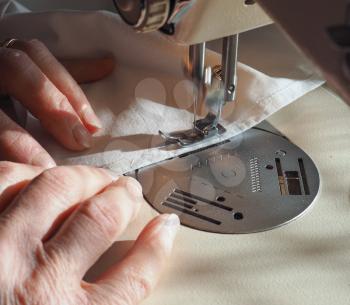 sewing machine to sew pieces of cloth together, motion blur showing needle movement