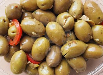 Green Olives (Olea europaea sylvestris) vegetables with hot chilli peppers vegetarian food in a plastic tub