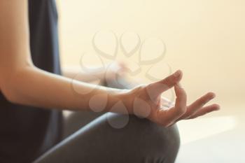 Young woman practicing yoga on light background�