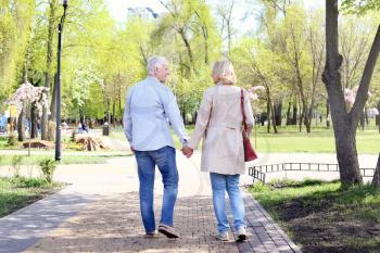 Mature couple walking in park on spring day�