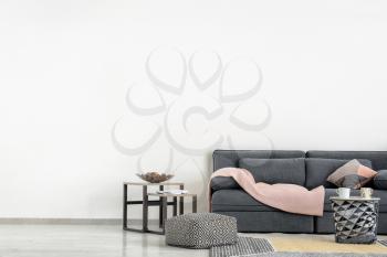 Stylish furniture with comfortable sofa near light wall�