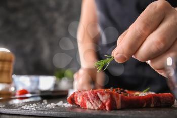 Man preparing meat in kitchen, closeup�