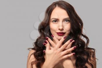 Beautiful young woman with professional manicure on light background�