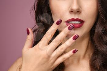 Beautiful young woman with professional manicure on color background, closeup�
