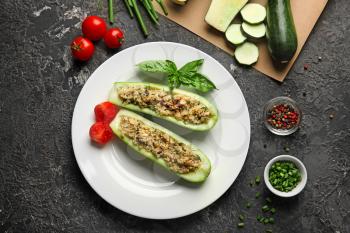 Plate with quinoa stuffed zucchini boats and vegetables on grunge table�