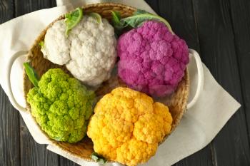 Basket with different cauliflower cabbage on wooden table�