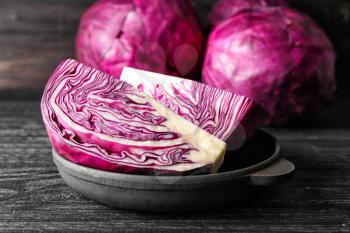 Frying pan with sliced red cabbage on wooden table, closeup�