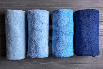 Clean soft towels on dark wooden table�