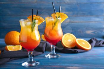 Fresh summer cocktail in glasses on color wooden table�