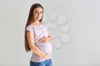 Beautiful pregnant woman on light background�
