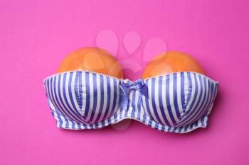 Ripe grapefruits in bra on color background�